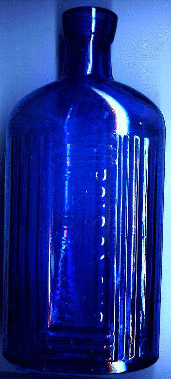 large blue victorian poison bottle: it says POISONOUS. NOT TO BE TAKEN