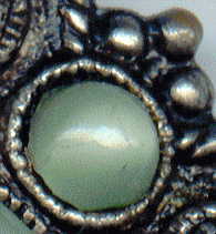 1940s? brooch with green satin glass cabochons: detail of small cabochon and metal frame detail