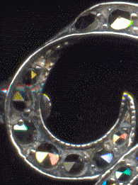detail of curlicue from top left of silver marcasite brooch